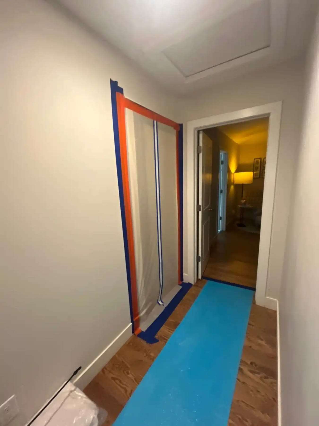 Hallway lined with containment plastic and a protective runner on the floor